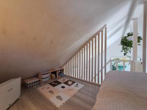 an attic room with a bed and a staircase at Jaanilille Tinytalo in Tahula