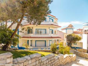 a large house with a stone wall in front of it at Apartamento em D'el Rey-Obidos Beach & Surf in Amoreira