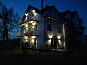 un edificio blanco con luces encendidas por la noche en Ferienwohnung Meyer, en Weissenburg in Bayern