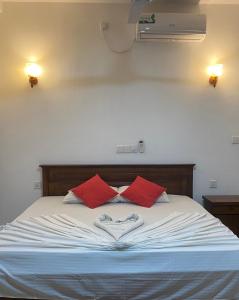 Cama con almohadas rojas y corazón en Nesh Villa en Aluthgama