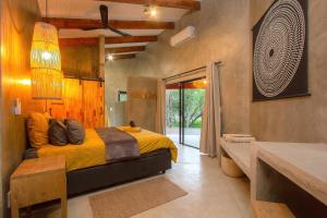 a bedroom with a bed with a yellow comforter at Ibhubesi house in Marloth Park
