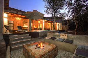 a backyard with a fire pit and a house at Ibhubesi house in Marloth Park