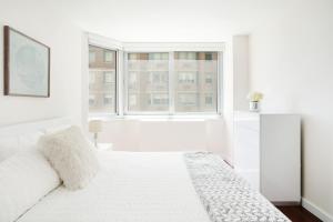 biała sypialnia z łóżkiem i oknem w obiekcie Apartment with a beautiful view w Nowym Jorku