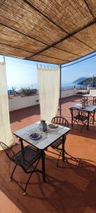 einen Tisch und Stühle auf einer Terrasse mit Sonnenschirm in der Unterkunft EnzoilNegro home in Lipari