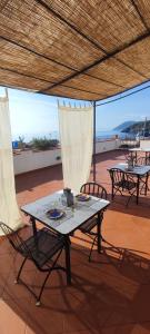 stół i krzesła na patio z parasolem w obiekcie EnzoilNegro home w mieście Lipari