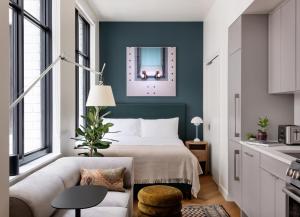 a bedroom with a bed with a green wall at ROOST Detroit in Detroit