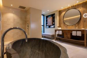 ein Badezimmer mit einer großen Badewanne und einem Spiegel in der Unterkunft Les Regalia Hôtel & Spa in Sainte-Lucie de Porto-Vecchio