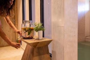 a woman standing on a table with a vase with a plant in it at Les Regalia Hôtel & Spa in Sainte-Lucie de Porto-Vecchio