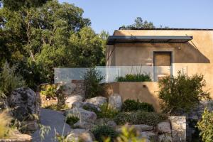 a house with a rock garden in front of it at Les Regalia Hôtel & Spa in Sainte-Lucie de Porto-Vecchio