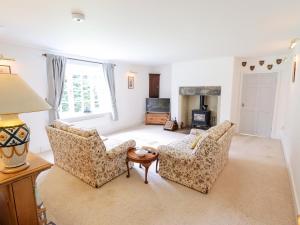 a living room with two chairs and a table at Pat's Cottage in Market Rasen