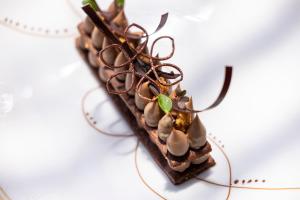 a dessert on a plate with chocolate drizzle at Les Regalia Hôtel & Spa in Sainte-Lucie de Porto-Vecchio