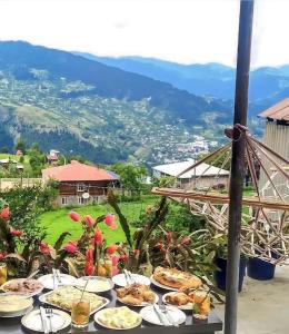 una mesa llena de comida con vistas a las montañas en Oda, en Khulo