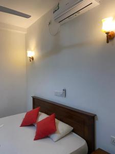 sypialnia z łóżkiem z 2 czerwonymi poduszkami w obiekcie Nesh Villa w mieście Aluthgama