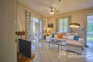 a living room with a white couch and a tv at Villetta Arcobaleno - Immobiliare Azzurra in Bardolino