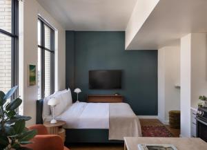 um quarto com uma cama e uma televisão na parede em ROOST Detroit em Detroit