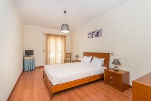 een slaapkamer met een bed, een bureau en een televisie bij Casa Mergoux - Maravilhoso Apartamento em Tavira in Tavira