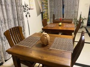 a wooden table with chairs and a stuffed animal on it at Nesh Villa in Aluthgama