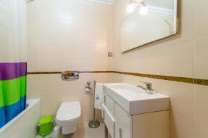 a bathroom with a sink and a toilet and a mirror at Casa Mergoux - Maravilhoso Apartamento em Tavira in Tavira