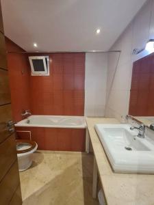 ein Badezimmer mit einer Badewanne, einem WC und einem Waschbecken in der Unterkunft Immense appartement familial lumineux haut de l Agdal in Rabat
