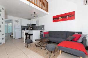 a living room with a couch and a kitchen at Face à la mer superbe villa terrasse barbecue LE PRADET in Carqueiranne