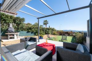 卡爾特漢的住宿－Face à la mer superbe villa terrasse barbecue LE PRADET，一个带桌椅的庭院和一个网球场