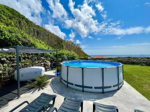 a hot tub sitting on a patio with chairs at Spot Milasmar in Faja Grande