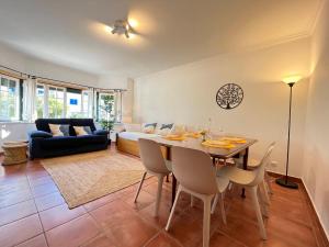 uma sala de estar com uma mesa e cadeiras e um sofá em Yellow House Ericeira na Ericeira