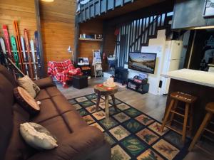 a living room with a couch and skis at Bills Big Bear Bunkhouse - Beautiful home within a short drive to all Big Bear has to offer! in Big Bear City