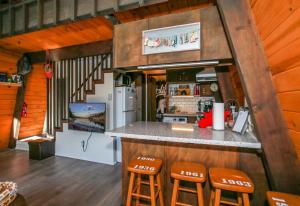 a kitchen with a counter and stools in a cabin at Bills Big Bear Bunkhouse - Beautiful home within a short drive to all Big Bear has to offer! in Big Bear City