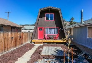a small house with a red door and a red chair at Bills Big Bear Bunkhouse - Beautiful home within a short drive to all Big Bear has to offer! in Big Bear City