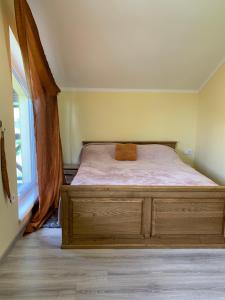 1 dormitorio con 1 cama con tocador y ventana en Лісова хатина, en Pilipets
