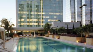 a large swimming pool in a building with tall buildings at Hotel AKA Brickell in Miami