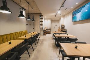 an empty restaurant with wooden tables and chairs at Dot Tradition in Vlorë