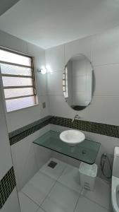 a bathroom with a sink and a mirror at Nuh Hostel - Lourdes in Belo Horizonte