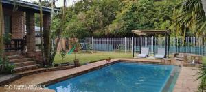 a swimming pool in a yard next to a fence at Sthembile's guest house in Richards Bay
