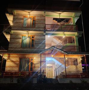 un edificio alto de ladrillo con una puerta por la noche en Delight Homestay Kasol en Kasol