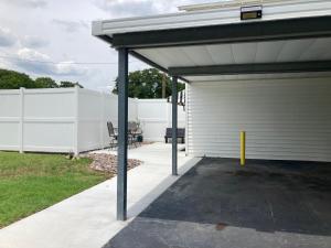 a garage with awning next to a white fence at The Old Liberty Schoolhouse in Azle