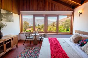 een slaapkamer met een bed, een tafel en een raam bij Viscas Lodge in Carhuaz