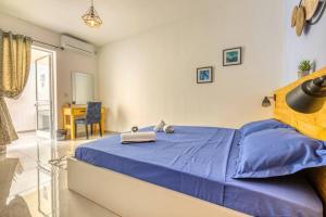 a bedroom with a blue bed and a table at Mag2 - One of a Kind 3 Bed Rabat in Ħal-Bajjada
