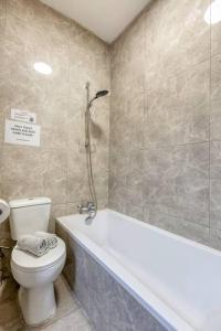 a bathroom with a toilet and a tub and a shower at Mag2 - One of a Kind 3 Bed Rabat in Ħal-Bajjada