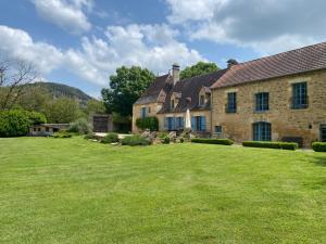 an old stone house with a large yard at Par La Rivière in La Roque-Gageac