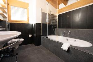 a bathroom with a white tub and a sink at Modern apartment with view over Zermatt in Zermatt