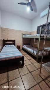 Cette chambre comprend 2 lits superposés et un ventilateur de plafond. dans l'établissement HOTEL AMAZ, à Ribeirão Preto