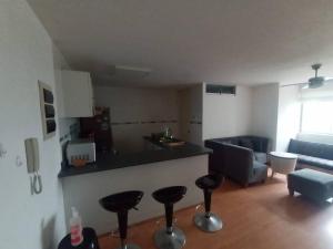 eine Küche und ein Wohnzimmer mit Hockern in einem Zimmer in der Unterkunft Departamento para un buen descanso in Lima