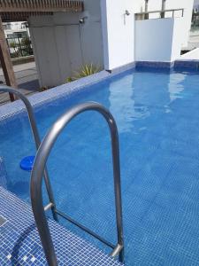 a swimming pool with a metal railing in the water at Departamento para un buen descanso in Lima