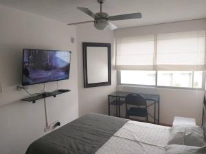 Schlafzimmer mit einem Bett und einem Flachbild-TV in der Unterkunft Departamento para un buen descanso in Lima