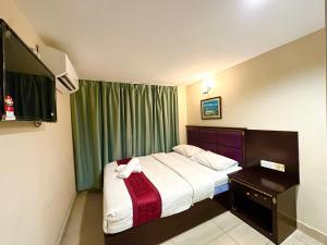 een slaapkamer met een bed en een groen gordijn bij VALLEY HOTEL in Kota Kinabalu