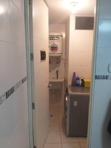 a small bathroom with a sink and a washing machine at Departamento para un buen descanso in Lima