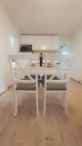 a white dining room table with two white chairs at Two bedroom apartment Bambi in Vir