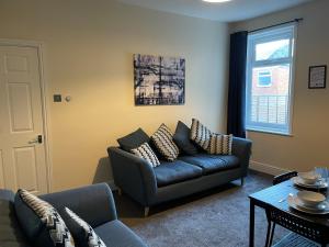 a living room with a couch and a table at Howe - Newly refurbished 2 bedroom flat Free Parking in Gateshead